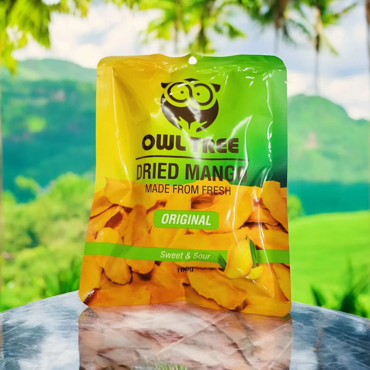 OWLTREE Dried Mango Original pack outdoors among green hills